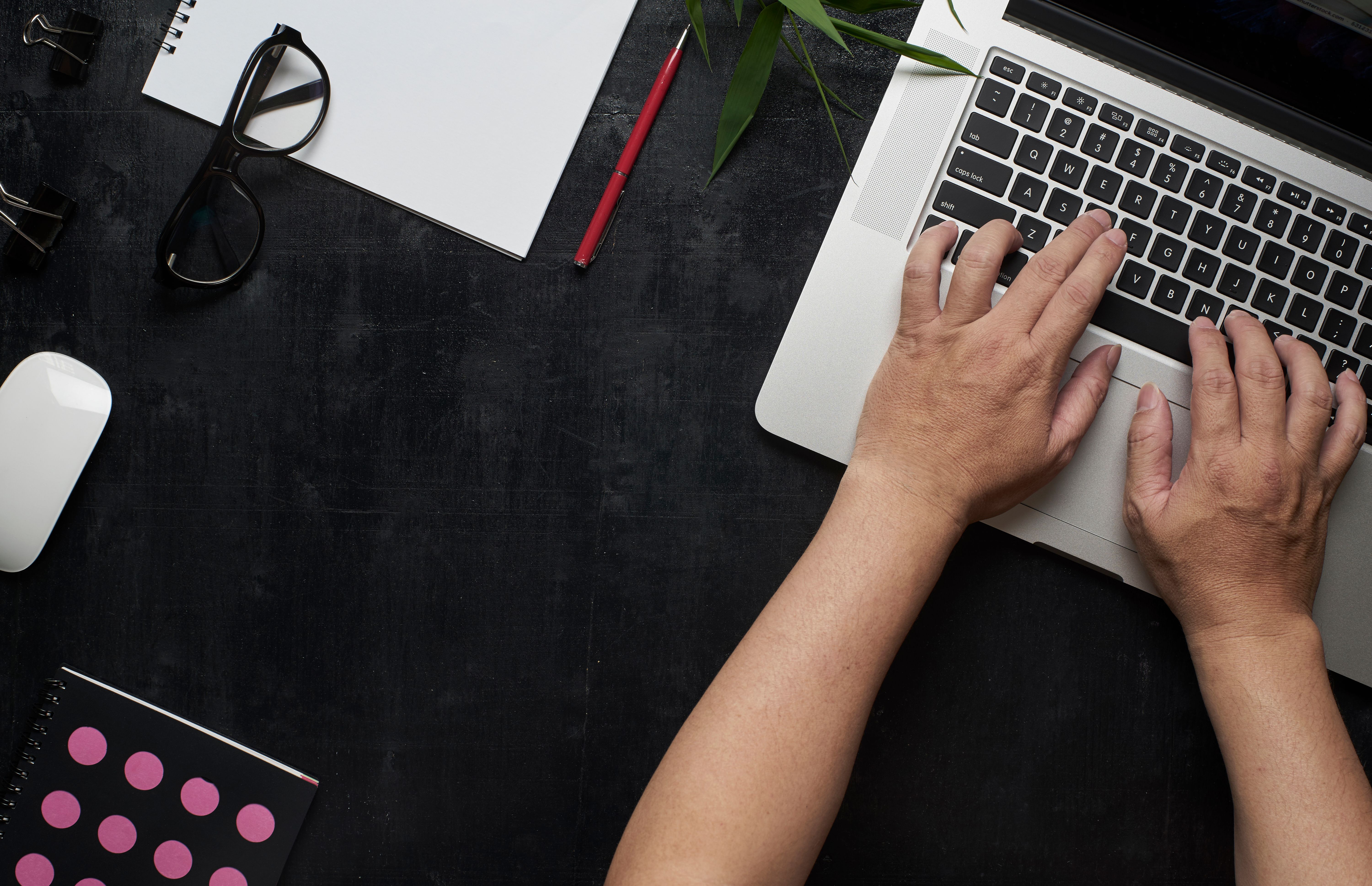 workspace-with-laptop-male-hands-notebookeyeglasses-sketchbook-black-wooden-desk-with--SBI-301984738